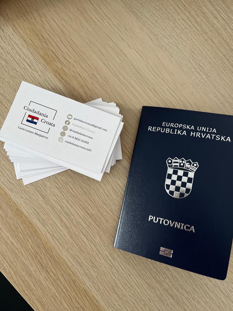 Pasaporte-y-tarjeta-cc Pasaporte croata junto a tarjetas de contacto de Ciudadanía Croata sobre una mesa de madera