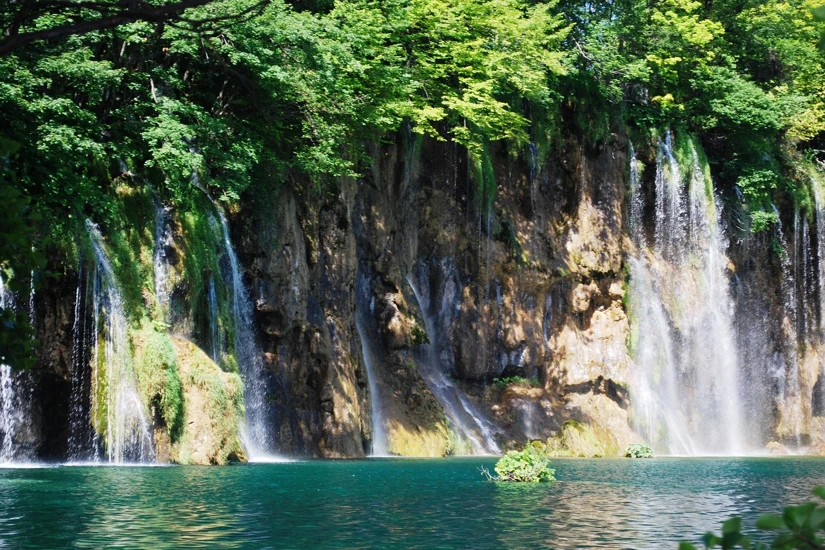  Vistas de cascadas cayendo sobre aguas turquesa en los lagos de Plitvice, rodeadas de vegetación