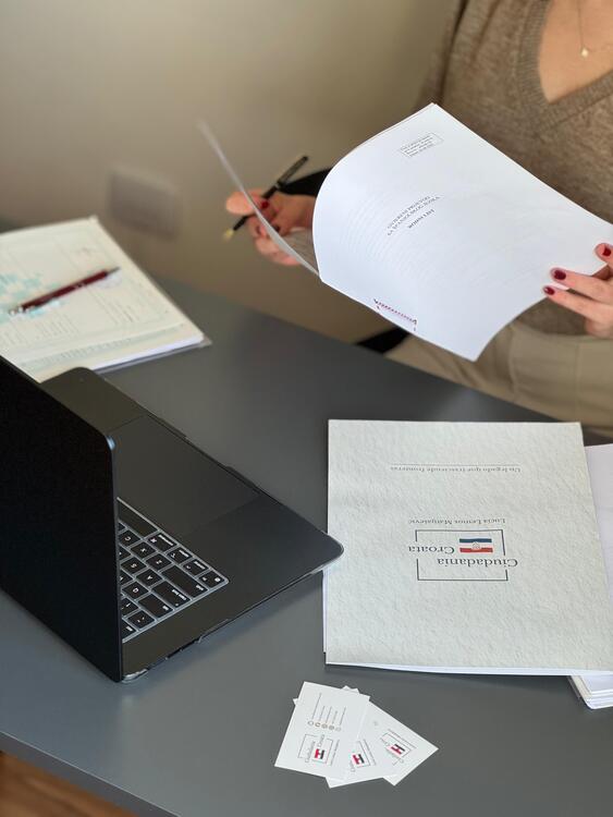 Documentación sobre una mesa con laptop abierta y carpeta de Ciudadanía Croata durante una investigación genealógica
