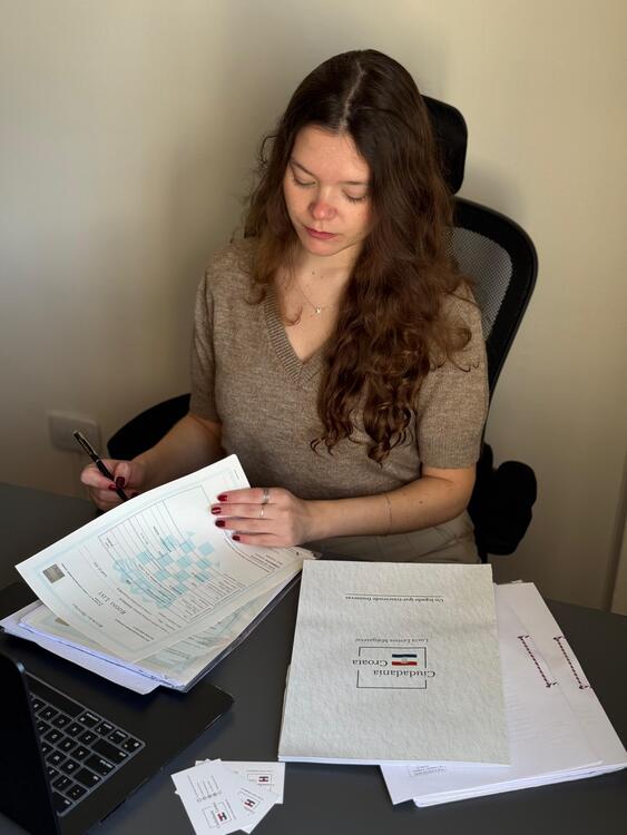 Lucía – Ciudadanía Croata Lucía revisando documentación para ciudadanía croata en su escritorio