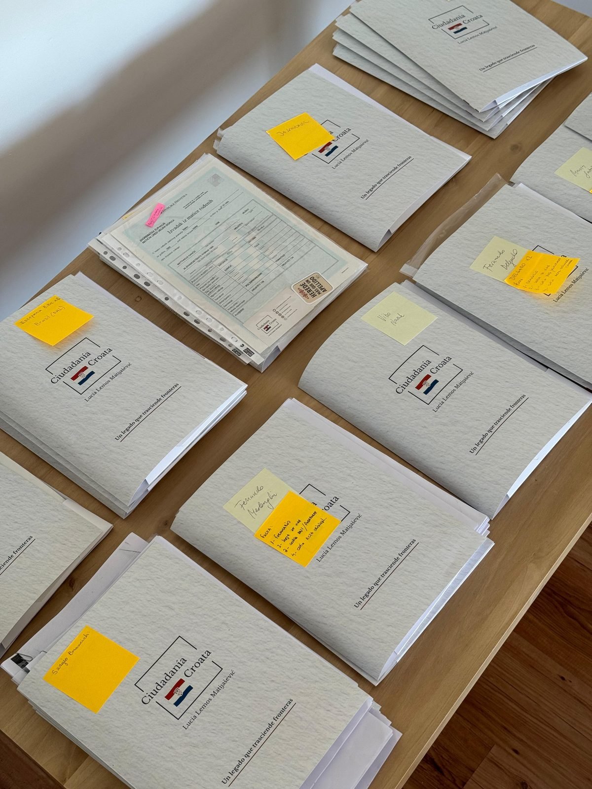 Carpetas de trámites de ciudadanía croata ordenadas sobre una mesa, listas para presentar en el consulado