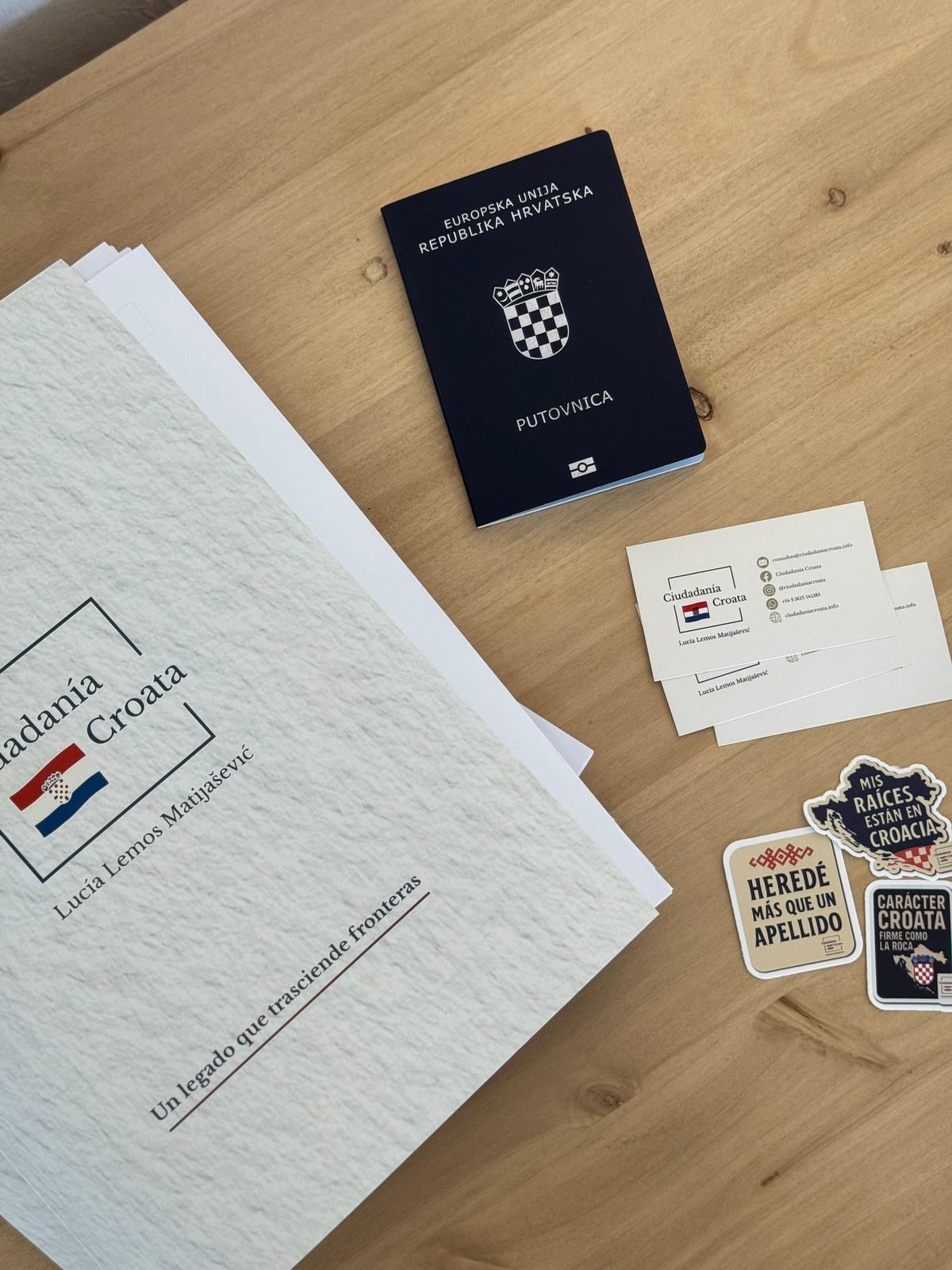 Pasaporte de la República de Croacia sobre una mesa de madera junto a documentación del trámite