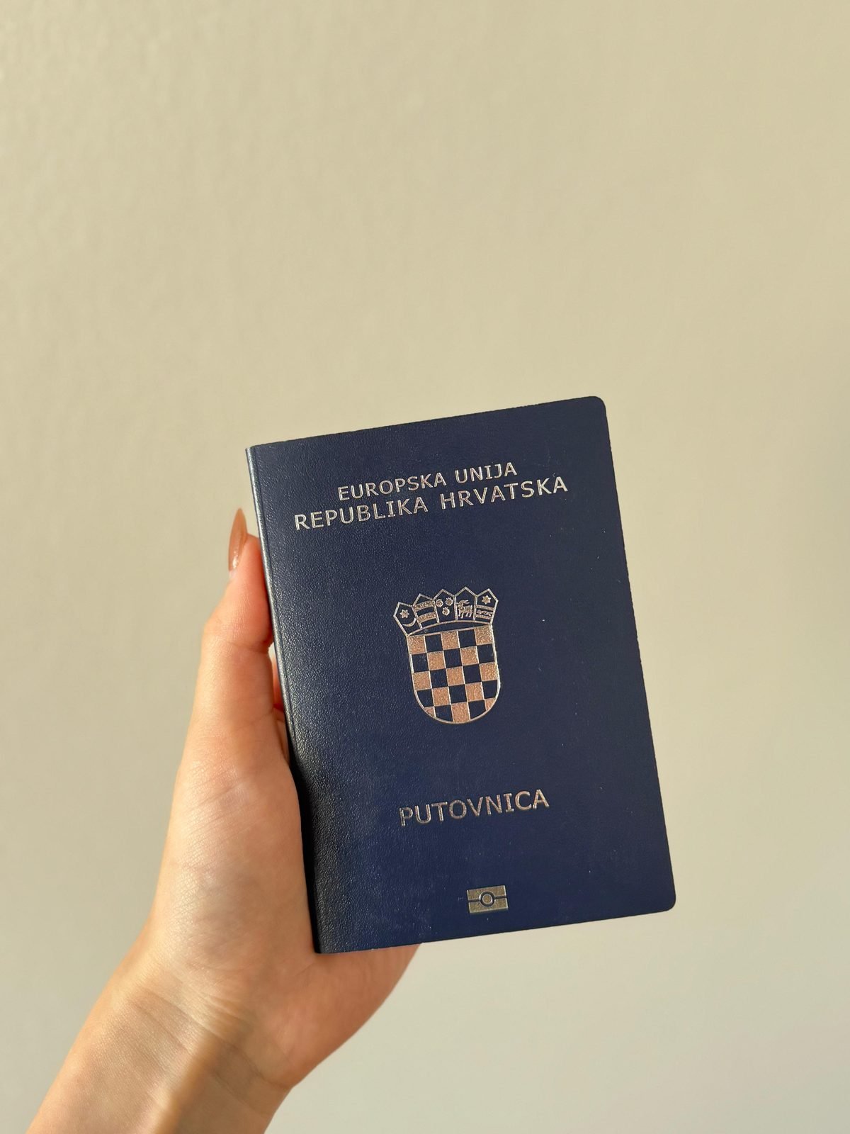 Mano sosteniendo un pasaporte de la República de Croacia